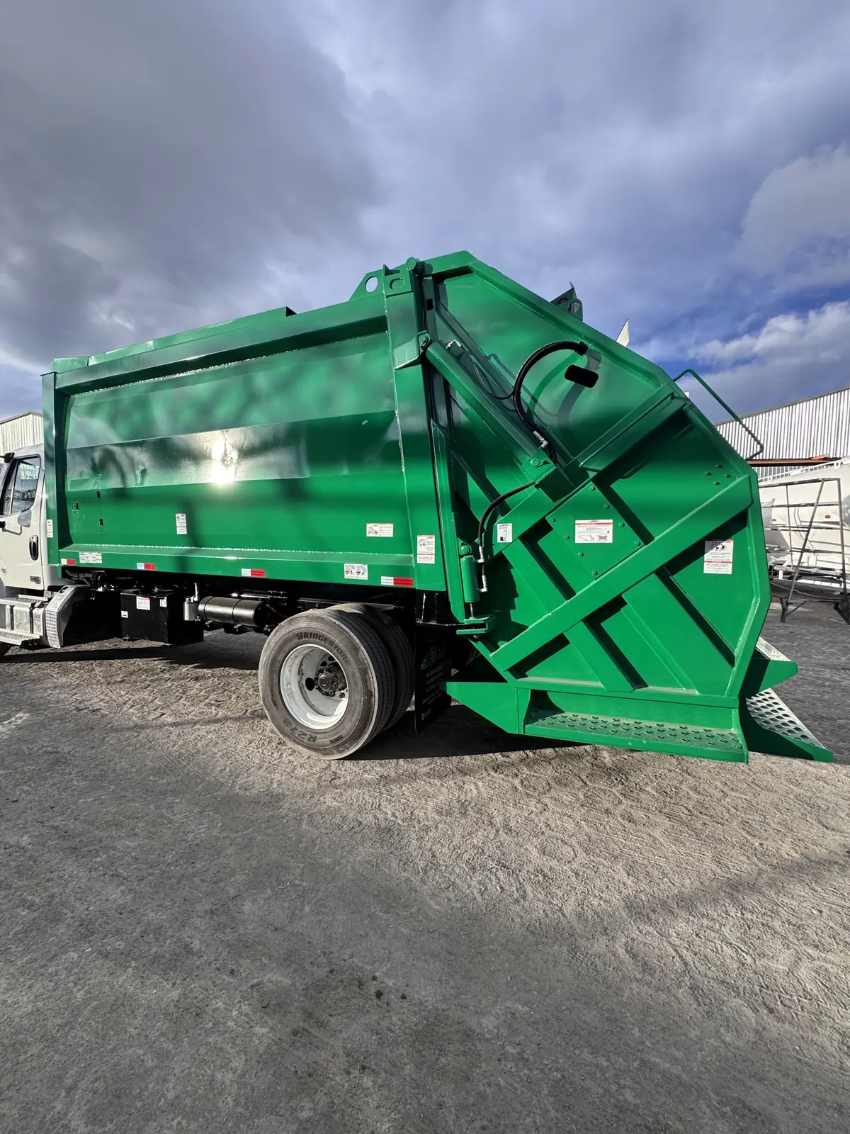 Compactador de carga trasera MSA verde en vista tres cuartos